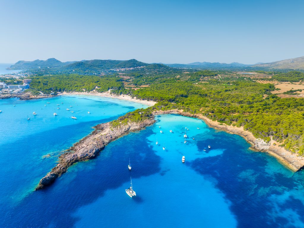 Mallorca yacht charter at Cala Agulla beach Mallorca turquoise water aerial Mediterranean yacht anchorage