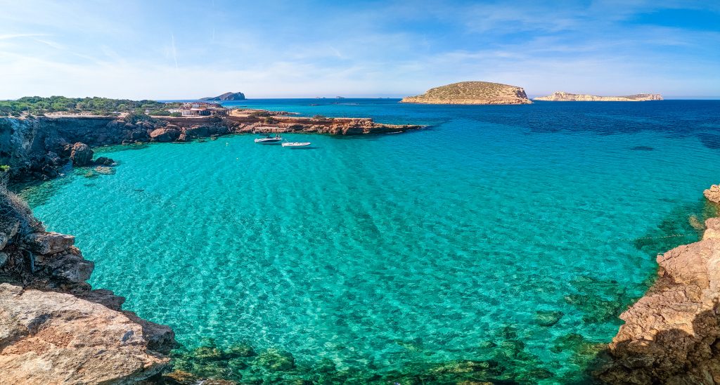 Ibiza yacht charter at Turquoise sea aerial view Cala Comte beach Ibiza luxury yacht anchorage