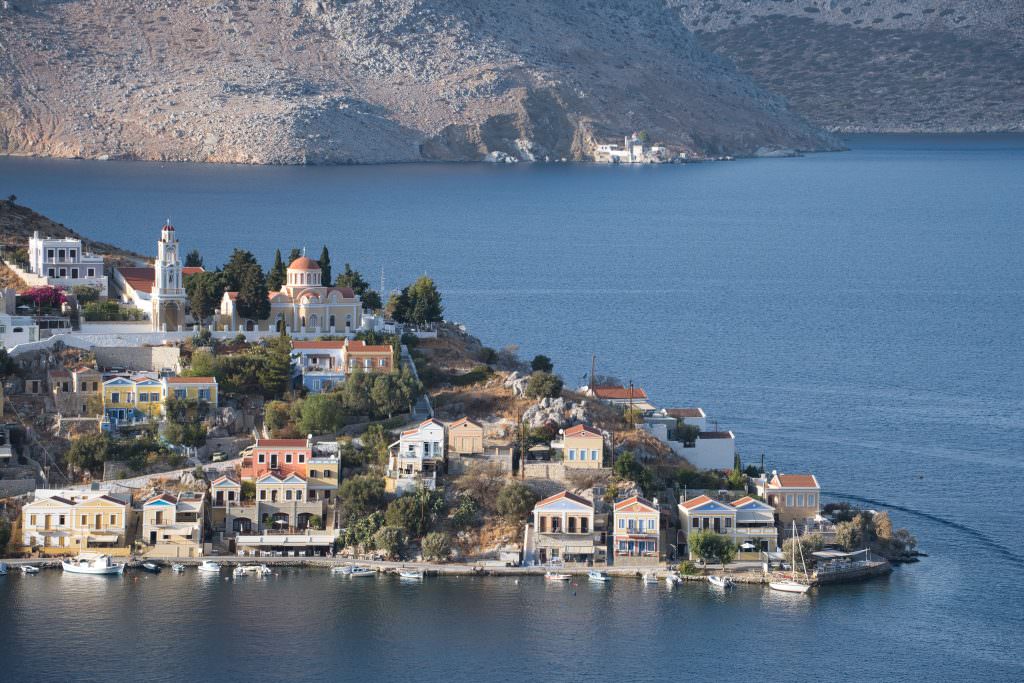 Symi Panormitis Monastery coastal view Greece colorful houses harbour blue sea luxury yacht charter destination