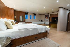 De Love motor sailer master suite with lounge area, spacious luxury yacht charter cabin featuring elegant design, seating space and premium comfort