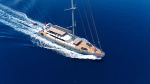 North Wind yacht charter motor sailer aerial view, luxury yacht cruising in deep blue sea with elegant design and premium charter experience