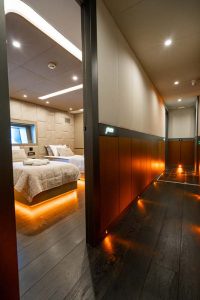North Wind motor sailer cabin corridor view, luxury yacht interior showing guest cabin entrance, elegant hallway lighting and modern design details