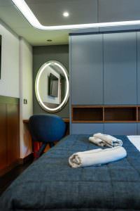 North Wind motor sailer cabin detail, luxury yacht bedroom with modern wardrobe, vanity area, ambient lighting and elegant interior design