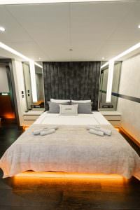 North Wind motor sailer master cabin front view, luxury yacht bedroom with elegant headboard, ambient lighting and symmetrical modern design