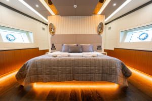 North Wind motor sailer master cabin symmetrical view, luxury yacht bedroom with elegant headboard, ambient lighting and refined modern interior design