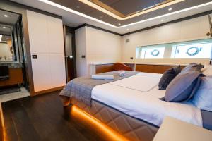 North Wind motor sailer master cabin wide view, luxury yacht suite with spacious bed, elegant furnishings, ambient lighting and modern interior design