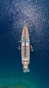 North Wind motor sailer top view drone shot, luxury yacht from above with symmetrical deck layout and crystal clear blue sea