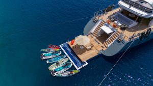 North Wind motor sailer water toys platform, luxury yacht with jet skis and paddle boards on swim platform in crystal clear blue sea