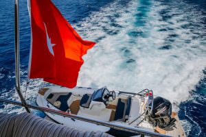 Reis yacht tender boat with Turkish flag cruising at sea, luxury yacht charter experience